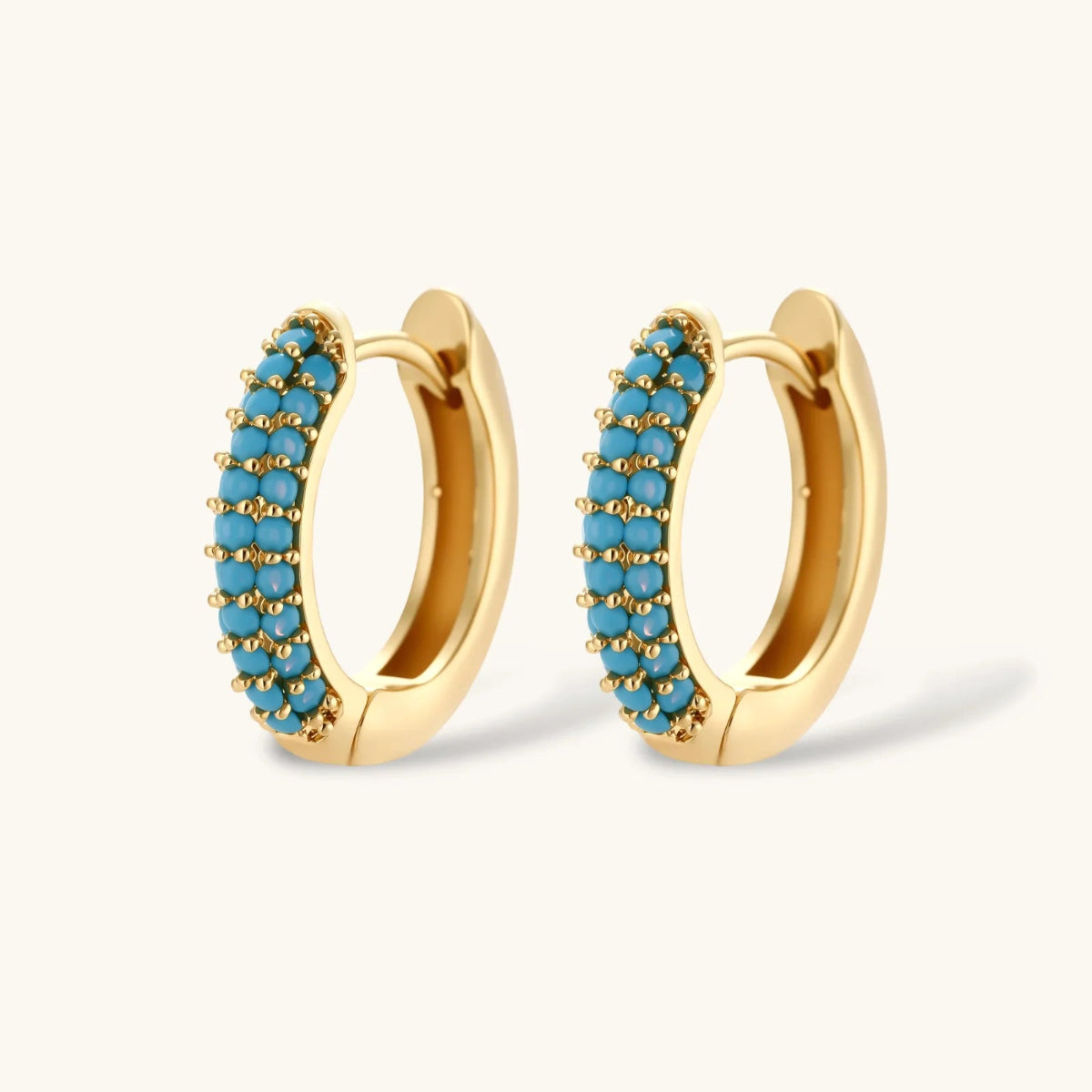 Gold-plated curved necklace and hoop earrings with turquoise cubic zirconia stones .