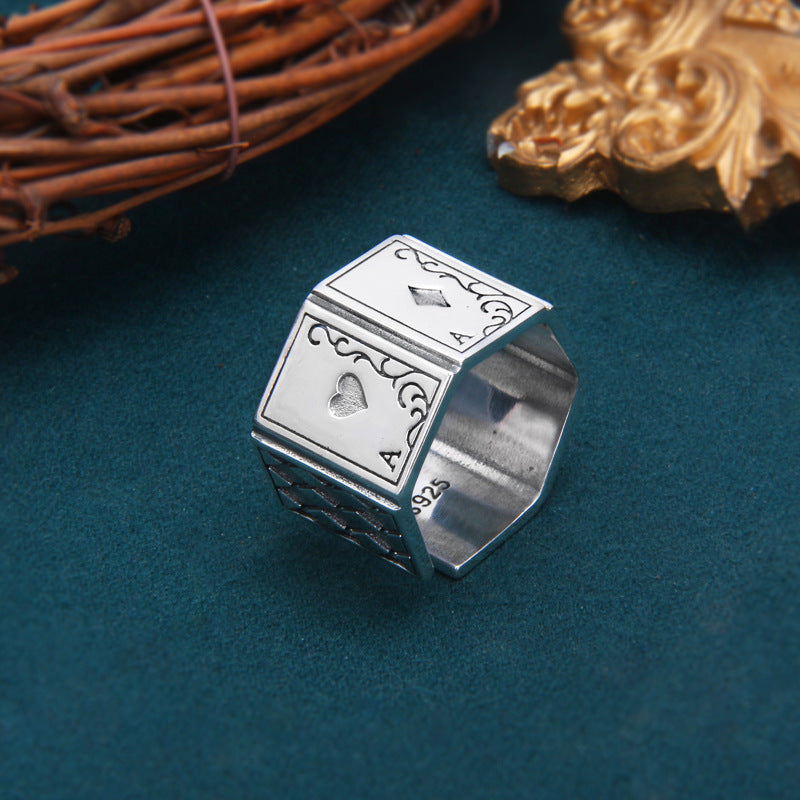 Silver ring with card design on a dark blue background